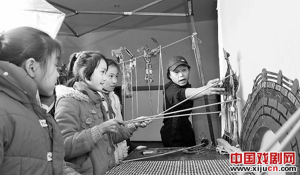 为30多名留守儿童表演并教授皮影戏