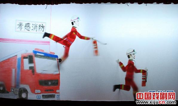 消防官兵为观众演示&ldquo;消防皮影&rdquo;