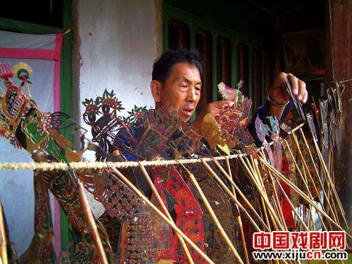 灯皮影戏 "一盏灯、布围框、皮刻人、半面脸"
